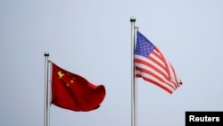 2021 年 4 月 14 日,美中两国国旗在中国上海的一家公司大楼外飘扬。(路透社资料照片)