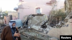 一位男士在查看巴格达以北的一处汽车炸弹袭击现场。(2014年1月20日)