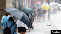 香港防暴警察用胡椒喷剂驱散利用午餐时间抗议国旗法的示威者。(路透社2020年5月27日)