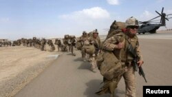FILE - U.U.S. Marines prepare to depart at the end of operations for Marines and British combat troops in Helmand, Afghanistan, Oct. 27, 2014.