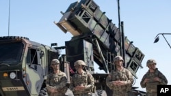 资料照片:在立陶宛参加北约演习的美国第10陆军空中与导弹防御司令部的军人站在一套“爱国者”防空导弹系统旁。(2017年7月20日)