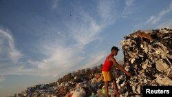 A boy looks for recyclable waste at a rubbish dump outside Yangon January 7, 2016. REUTERS/Soe Zeya Tun - RTX21FSN