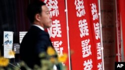 一名男子走过东京日本自民党总部竖立的竞选总裁的旗帜。(2024年9月12日)