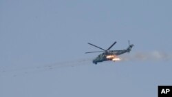 资料照片:缅甸空军一架直升机在联合演习中进行实弹射击。(2018年2月2日)