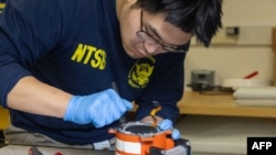 这张2025年1月31日从美国国家运输安全委员会(NTSB)获得的照片显示,NTSB调查人员正在检查美国航空公司5342航班的黑匣子。