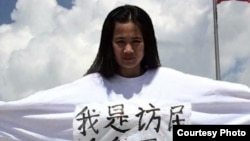 资料照:强拆抗争者李焕君身穿写有“我是访民 向我开枪”的上衣保卫家园。(2015年5月18日)