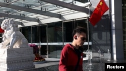 北京金融街一座办公楼前的石狮子和中国国旗。(2024年10月8日)