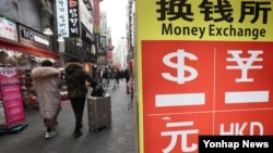 资料照片: 外国游客正前往位于首尔中区明洞街的货币兑换处