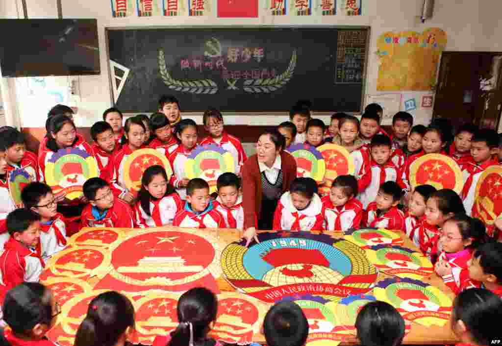 中国两会前夕，重庆一所小学的学生们学习关于中国国徽、政协会徽、全国人民代表大会和中国人民政治协商会议的知识（2018年3月1日）。