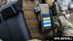 Шеврони бійця легіону "Свобода Росії": український прапор та неофіційний біло-синьо-білий прапор російських супротивників режиму Путіна. Фото: AFP/RFE/RL