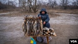 2023年1月23日,虽然炮弹经常落在当地,但是谢尔盖·扎姆连科仍在恰索夫亚尔城外的路边摆摊卖鱼。(美国之音博夏特拍摄)