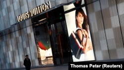 资料照片:一名男子走过路易威登奢侈品公司位于北京的专卖店。(图片摄于2016年11月30日。)