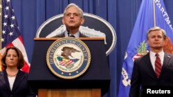 美国司法部长梅里克·加兰德和联邦调查局局长克里斯托弗·雷等官员在华盛顿的司法部总部举行记者会,宣布在三起案件中对包括中国情报人员及其代理人在内的13人提出指控。(2022年10月24日)