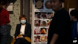 位于北京旅游景点的一家餐馆服务人员坐等顾客上门。(2022年10月7日)