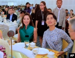 马来西亚女演员杨紫琼(Michelle Yeoh)与缅甸反对派领导人昂山素季(Aung San Suu Kyi)2014年3月9日在仰光的一次会议上坐在一起.