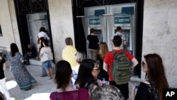 希腊一座北方城市的市民听到要全民公决的消息后赶到银行提款(2015年6月27日)