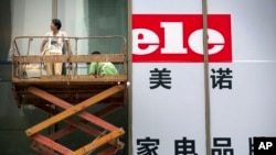 工人们为北京一家家用电器商店的大开张做准备。(2015年7月15日)