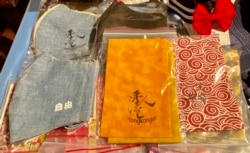 似水牛年迷你年宵市集售卖的布口罩、布利是封,印有象征抗争信念的标语 (美国之音汤惠芸)