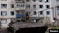 Український військовослужбовець сидить на верху бойової машини піхоти під час оборони Бахмута, 2 квітня 2023. REUTERS/Violeta Santos Moura