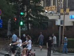 2020年6月14日傍晚,口罩防范疫情的路人在北京友谊商店周边。(美国之音叶兵拍摄)