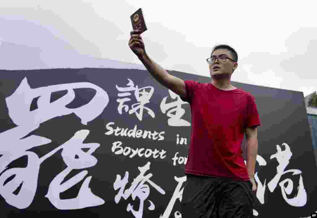在抗议者在香港中文大学举行罢课集会之际，一位来自中国大陆的学生高举自己的中国护照向抗议者示威。(2019年9月2日)