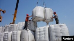 资料照:中国黑龙江省黑河港的工人正在卸下从俄罗斯进口的大豆。(2018年10月10日)