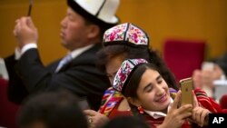 2016年3月8日,中国人大会议期间新疆代表在北京人民大会堂的用智能手机拍照。他们的手机是否被监控?国际人权组织“人权观察”说很多新疆穆斯林的手机受到监视。