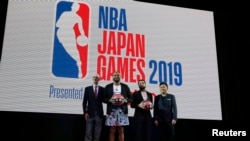 NBA联盟主席萧华(左)与休斯顿火箭队球员、多伦多猛龙队球员等人在日本东京举行的欢迎仪式上合影。(2019年10月7日)