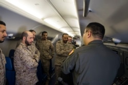 美国海军资料照片:分配入美国海军巡逻第5中队的战术协调员杨帆(右,音译)上尉在P-8A“海神”反潜飞机上向沙特皇家海军人员展示飞机的系统(2018年3月1日)。