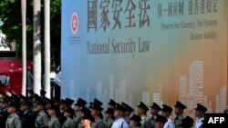 资料照:香港各种警察部队成员站在港版国安法广告牌前 (2020年7月1日)