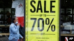 2020年5月21日行人走过克利夫兰一家商店促销广告