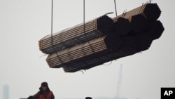 在中国唐山曹妃甸港口,工人把钢管装船。(2012年2月20日)中国钢铁产品受到欧盟制裁