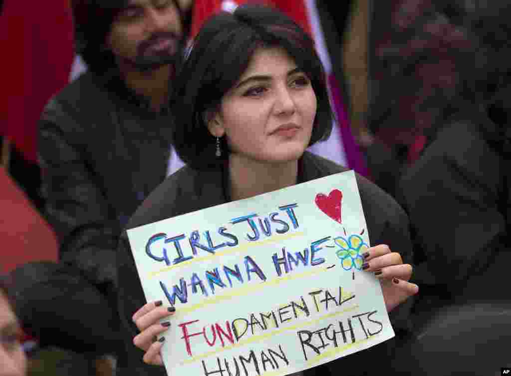 一名巴基斯坦妇女手持“女孩们只想拥有基本人权”海报参加在伊斯兰堡举行的国际妇女节集会活动(2019年3月8日)。