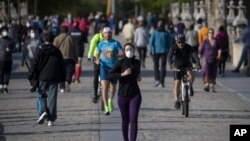 图为人们正在穿越西班牙马德里的托莱多大桥,周六,西班牙人能够外出锻炼,这是自封锁开始抗争以来的七周来的第一次。(2020年5月3日)
