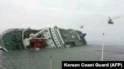 照片显示直升机前往搭救在前往济州岛途中出事的渡轮上的乘客。(2014年4月16日)
