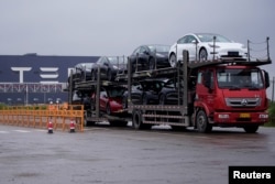 一辆大卡车运出特斯拉上海工厂出产的汽车。(2021年5月13日)