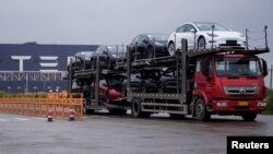 一辆大卡车运出特斯拉上海工厂出产的汽车。(2021年5月13日)