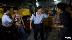 在香港旺角商业区的一场本土派示威中,警察检查“本土民主前线”的发言人黄台仰(左起第二人)的身份证(2015年6月21日)