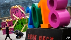 北京一家零售和批发商场大楼前写有“生意兴隆,财源广进“字样的商场装饰物。 (2018年7月)