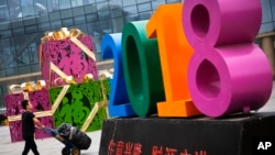 北京一家零售和批发商场大楼前写有“生意兴隆,财源广进“字样的商场装饰物。 (2018年7月9日)