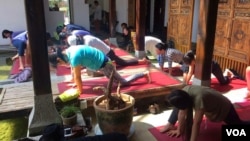 云南一家瑜伽会所的学员们正在练习流瑜伽。(美国之音朱诺拍摄,2015年10月8日)