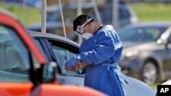 Nhân viên y tế tiếp nhận thông tin của người dân tới xét nghiệm COVID-19 ở Florida.