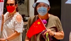 有白衣人支持者手持迷你中国国旗(美国之音/汤惠芸)