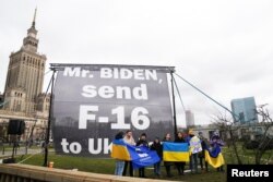 资料照片:支持乌克兰的抗议者在美国总统拜登访问波兰期间下榻的酒店外呼吁拜登批准向乌克兰提供美制F-16战斗机。(2023年2月22日)