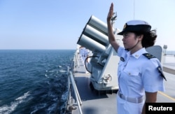 资料照:中俄海军在广东湛江海域举行联合军演后,一名中国海军士兵向俄罗斯舰队举手告别。(2016年9月19日)