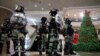 香港防暴警察在一个商场中站在一棵圣诞树旁面对示威者。（2019年12月24日）