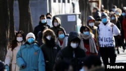 身穿厚保暖外衣的人群走过北京南锣鼓巷。(2021年1月16日)