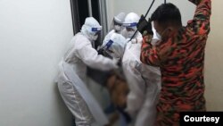 ဇွန်လ ၁၈ ရက်နေ့ ညက ကြိုးဆွဲချ သေဆုံးသူမြန်မာလူငယ်ကို မလေးအာဏာပိုင်တွေနဲ့ မြန်မာလူမူကူညီရေးအဖွဲ့က သယ်ဆောင်နေတဲ့ မြင်ကွင်း။ (ဇွန် ၁၈၊ ၂၀၂၀)