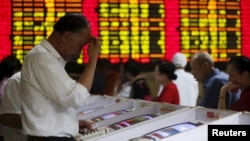 上海股民在股票交易所观看股市行情电子显示屏(2015年7月8日)