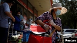 资料照:北京一家超市门口购物的市民。(2020年7月19日)